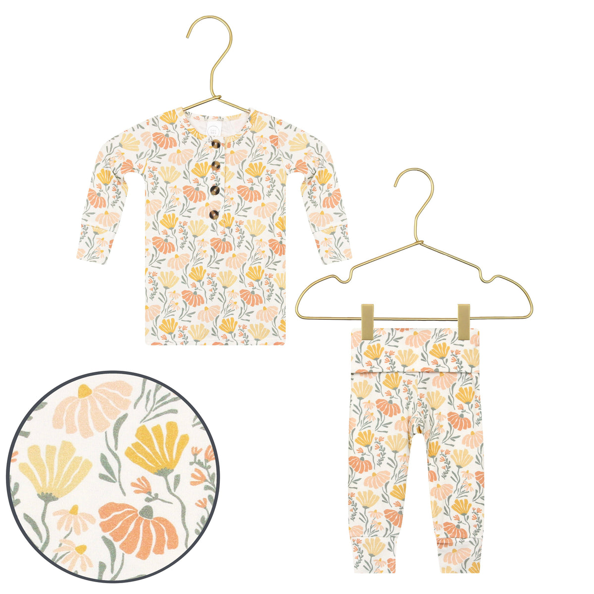 Floral-patterned baby outfit with a bib and pants on a hanger against a white background.